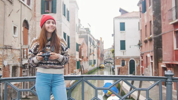 Uma jovem mulher de pé na ponte segurando uma câmera - Veneza, Itália — Fotografia de Stock