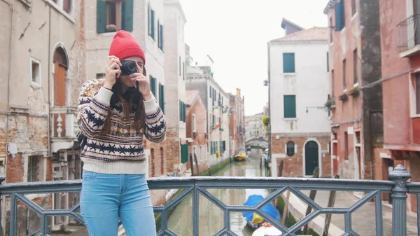 Uma jovem mulher de pé na ponte e tirando uma foto em sua câmera - Veneza, Itália — Fotografia de Stock