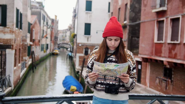 Uma jovem mulher em pé acima do canal de água e olhando para o mapa - Veneza, Itália — Fotografia de Stock