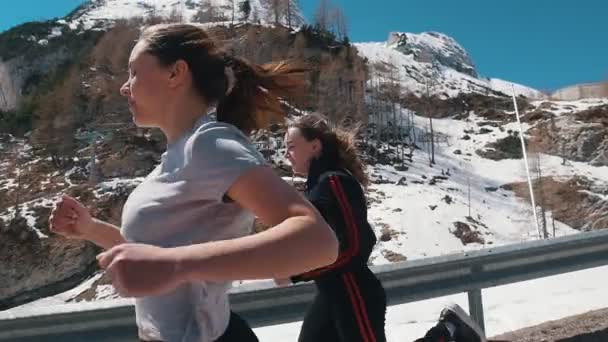 Dos jóvenes deportistas corriendo por la carretera - Dolomitas, Italia — Vídeos de Stock