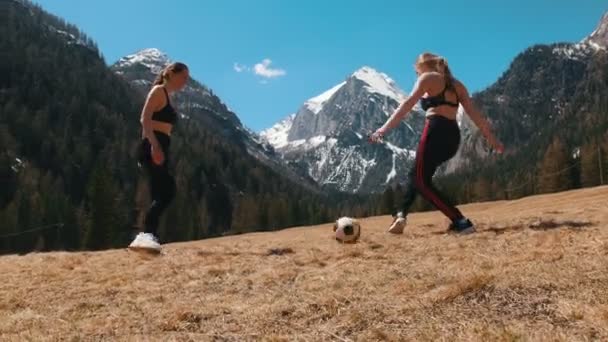 Dağların ve ormanın arka planında topla oynayan iki genç kadın - Dolomites, İtalya — Stok video