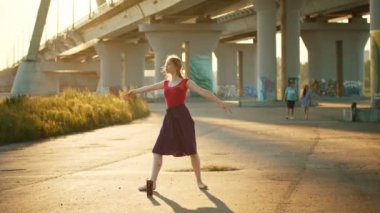 Köprü yakınında dans genç gülümseyen kadın balerin - bir dönüş performans