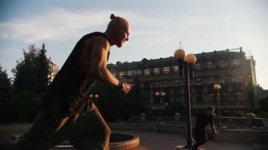 Akrobatik erkekler parkour hileler gerçekleştiren ve binaların bir arka plan üzerinde çevirir