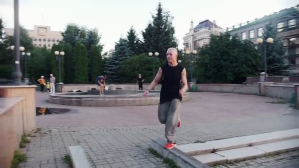 Akrobatiska män utför parkour trick-en man hoppar på gränsen och utföra en flip — Stockvideo