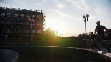 İki akrobatik adam kadar çalışan ve çeşme üzerinden atlamak - gün batımı
