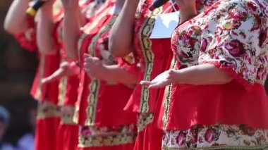 Bir grup yaşlı kadın folklor festivalinde şarkı söylüyor.