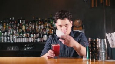 Genç profesyonel barmen bir peçete üzerine cam koymak ve ileriye doğru hareket eder