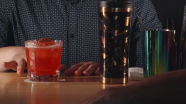 Barmen kokteylini bitiriyor ve müşteri alıyor.