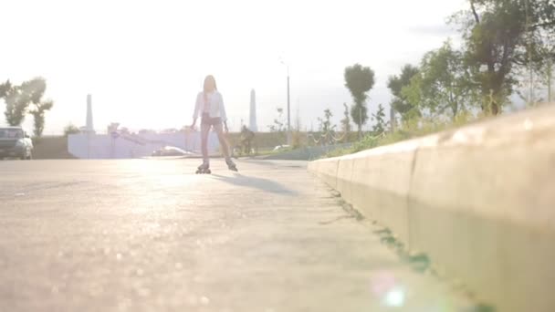 Ein romantisches Teenager-Mädchen auf Rollschuhen, das auf der Straße Schlittschuh läuft - Sonnenuntergang — Stockvideo