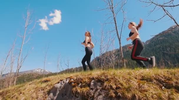 Dos jóvenes deportistas corriendo hacia arriba en la colina - Dolomitas, Italia — Vídeos de Stock