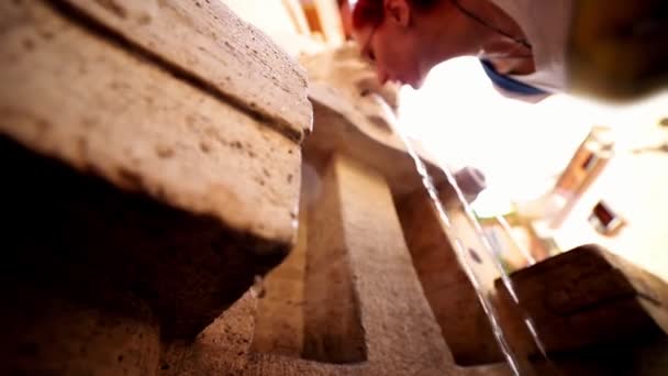 Mujer bebiendo agua de la escultura de la fuente - El agua cae — Vídeos de Stock