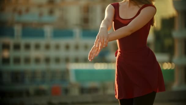 Jovem mulher bonita bailarina em vestido vermelho de pé no telhado - dançando com as mãos - pôr do sol brilhante — Vídeo de Stock