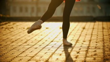 Çatıda dans eden genç kadın balerin bacakları - gün batımı
