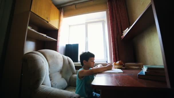 Un niño pequeño escribiendo algo en el cuaderno - haciendo la tarea — Vídeo de stock