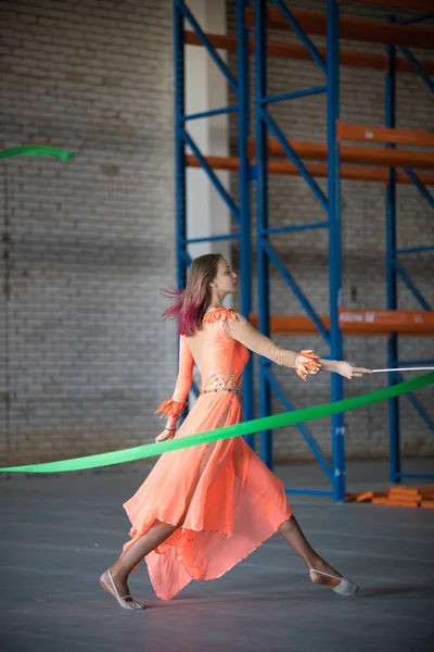 Mujer joven circo permomer bailando con cinta de gimnasia en las manos indoor —  Fotos de Stock