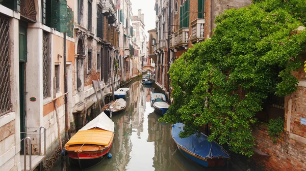 Smala gatorna i Venedig med kanal fylld med vatten-förtöjda båtar — Stockfoto