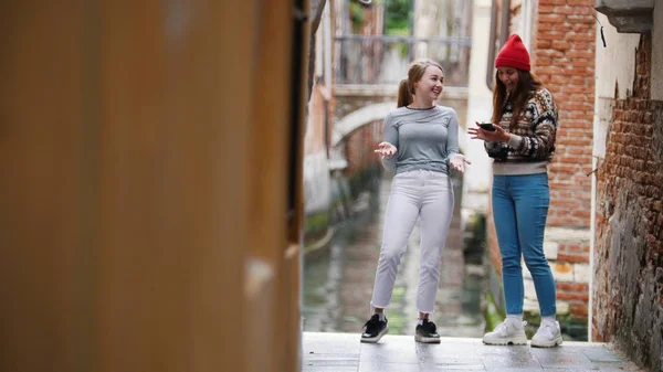 Dos mujeres jóvenes están mirando por teléfono. En las calles de Venecia . —  Fotos de Stock