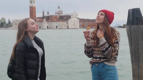 两个年轻女子站在码头上。其中一人吃冰淇淋 — 图库照片