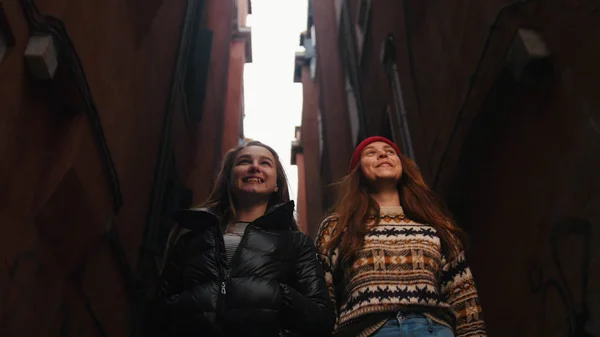 Δύο νεαρές χαμογελαστοί γυναίκες περπατούν στο στενό δρόμο — Φωτογραφία Αρχείου