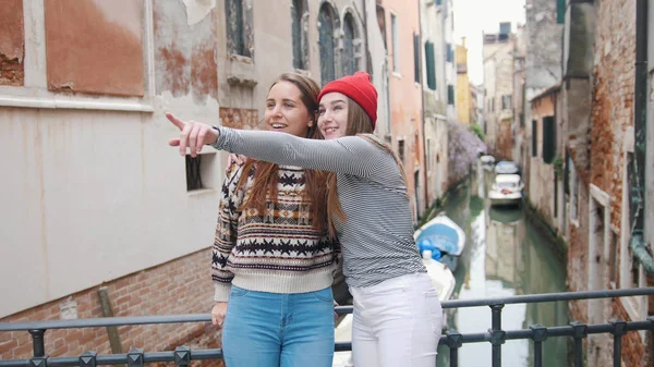 Δύο νεαρές γυναίκες περπατούν στους δρόμους της Βενετίας-ένας από αυτούς δείχνει κάτι σε άλλους — Φωτογραφία Αρχείου