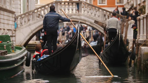 男は手にパドルを持つ人々とボートの上に立っている - ヴェネツィアの運河についての旅 — ストック写真
