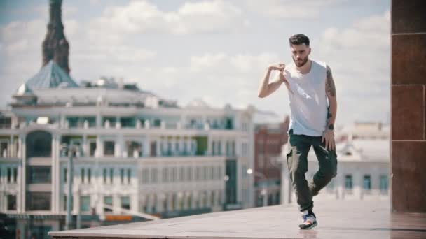 Молодий стильний чоловік вільний стиль танцює на підставці - центр міста на фоні — стокове відео