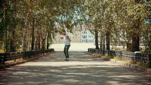 Fiatal vonzó férfi tetoválás teljesítő zár táncol a parkban, és élvezi magát-épületek a háttérben — Stock videók