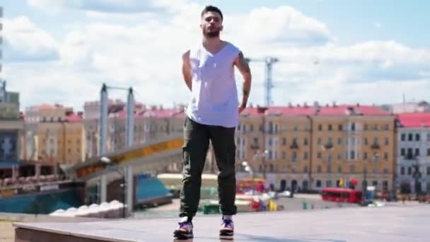 Young stylish man freestyle dancing on the top point in the centre of the city — Stock Video