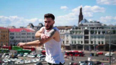 Şehir merkezinde üst noktada dövmeler freestyle dans ile genç çekici adam - kamera bakarak