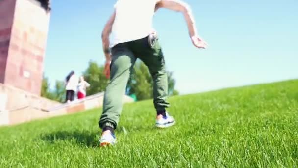 Giovane uomo attraente con tatuaggi freestyle danza - camminando verso l'alto sulla fresca erba verde — Video Stock