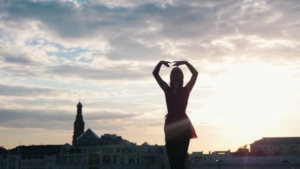 Dançarina de balé mulher atraente fazendo exercícios de balé ao ar livre, enquanto o pôr do sol — Vídeo de Stock