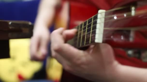 Un uomo che suona la chitarra acustica con un plettro — Video Stock