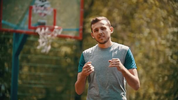 Een man gooien van de bal in de basketbal hoepel en het raken van het doel-het tonen van oke gebaar — Stockvideo