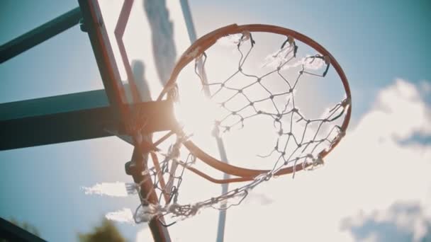 Ein Basketballtraining draußen. einen Ball in einen Basketballkorb werfen. Der Ball landet genau im Tor — Stockvideo