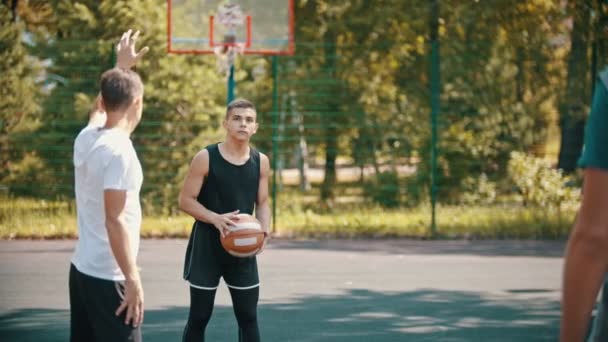 Kamarádi hrají basketbal na sportovním terénu-muž, který míří do zápletu a hází míč — Stock video