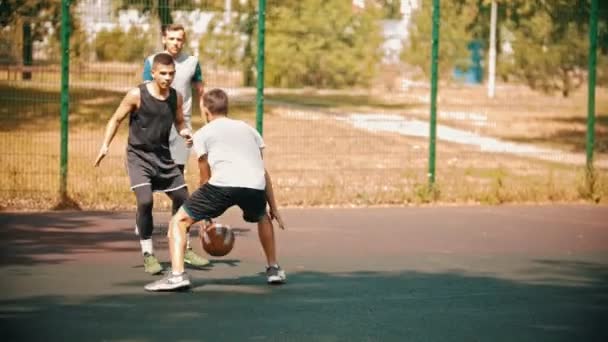 Νέος άνθρωπος παίζοντας μπάσκετ στο αθλητικό έδαφος με τους φίλους-να πάρει μια Βαθμολογία — Αρχείο Βίντεο