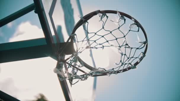 En basket hoop. Nätet fladdrande i vinden. Starkt solljus — Stockvideo