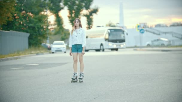 Uma adolescente tímida em patins de pé na estrada — Vídeo de Stock