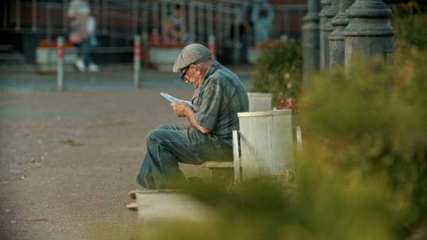 Kazań, Rosja-14 lipca 2019: stary człowiek siedzi na ławce i czytając książkę — Wideo stockowe