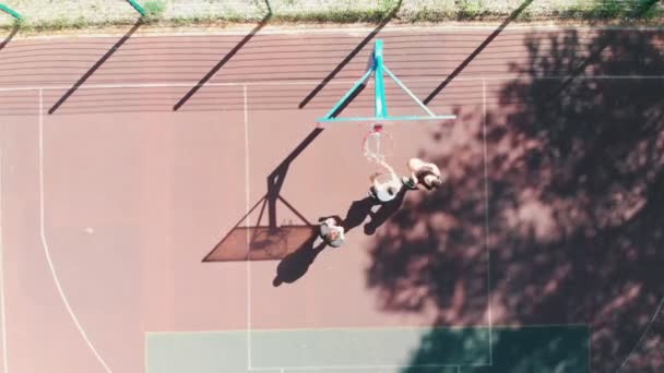 Jeunes hommes en forme jouant au basket sur le terrain de sport en plein air — Video