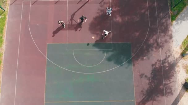 Giovani uomini in forma che giocano a basket sul campo in strada — Video Stock