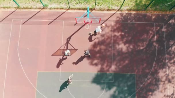 Junge fitte Männer spielen Basketball auf dem Sportplatz auf der Straße — Stockvideo