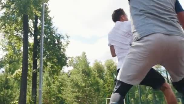 Young man playing basketball outdoors with friend and scoring goal — Stock Video