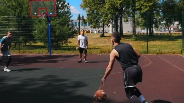Młody sportowca gra w koszykówkę na zewnątrz z przyjaciółmi, drybling i brakuje koszyka — Wideo stockowe