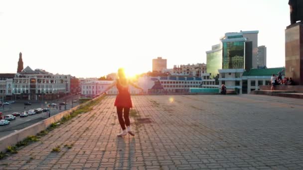 年轻女子芭蕾舞女训练她的舞蹈在屋顶上 - 跳跃和表演分裂 - 明亮的日落 — 图库视频影像