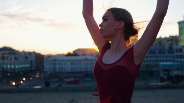 Young attractive ballerina aesthetically and gracefully rotate around herself in the dance at the background of the evening city — Stock Video