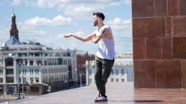 Standda genç şık adam serbest dans - arka planda şehrin merkezi