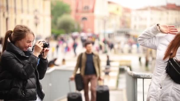 Две молодые женщины фотографируют друг друга на улицах Венеции — стоковое видео