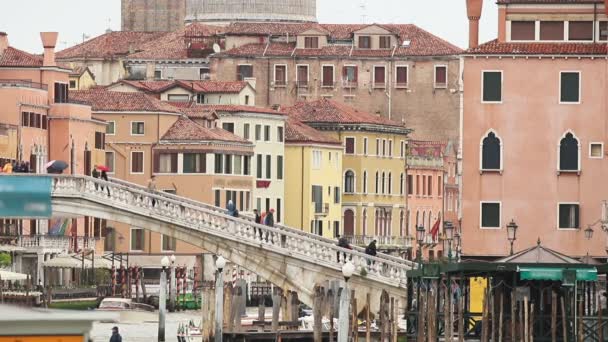 As ruas de Veneza, uma multidão de pessoas caminham na ponte do outro lado do rio entre as ruas — Vídeo de Stock