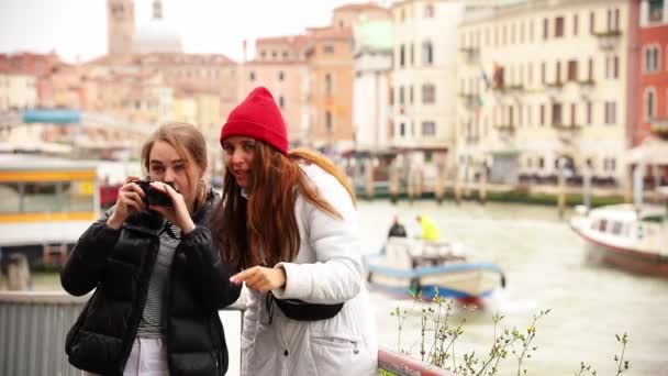 Zwei junge frauen fotografieren die umgebung auf den straßen venezias — Stockvideo